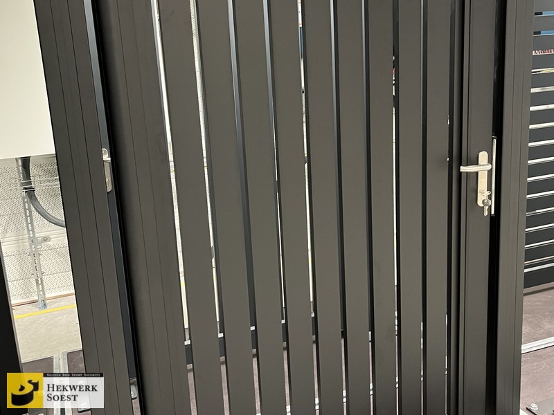 Hekwerk Soest B.V. | Sierhekwerk en Sierpoorten - Vooraanzicht van een aluminium poort met verticale lamellen.